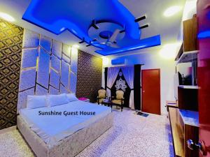 a bedroom with a bed and a blue ceiling at Sunshine Guest House in Dargai