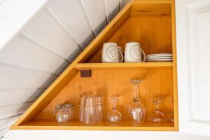 a wooden shelf with glasses and vases on it at Stepin in Kiskunfélegyháza