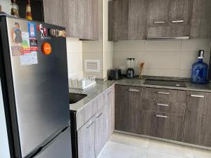 eine Küche mit Edelstahlkühlschrank und Holzschränken in der Unterkunft Ruta 2Cabañas Ruta del Lago in Puerto Varas