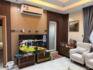 a living room with a video game on the tv at شقق الفندقية للتأجير اليومي in Fulūj Sayghah