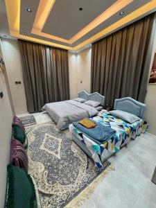 a bedroom with two beds and a rug at شقق الفندقية للتأجير اليومي in Fulūj Sayghah