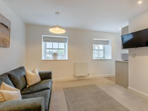 un salon avec un canapé et une télévision à écran plat dans l'établissement Uk46867 - Thirlmere, à Ulverston