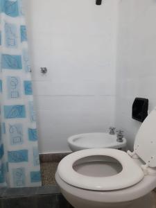 une salle de bain avec des toilettes blanches et un lavabo dans l'établissement La Vecindad del Sol Depto H, à Miramar