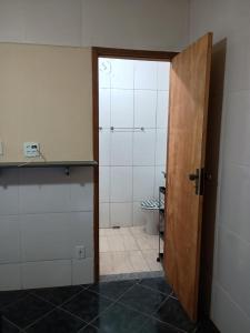 une porte ouverte menant à une salle de bains pourvue de toilettes. dans l'établissement Casa com cozinha americana, à Araruama