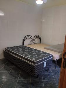 une chambre avec un matelas posé à même le sol à côté d'un lit dans l'établissement Casa com cozinha americana, à Araruama