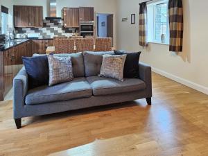 un sofá en una sala de estar con cocina en Beudy-Oh2, en Dihewid