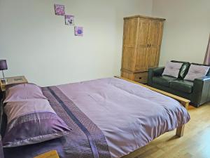 Un dormitorio con una cama y una silla verde. en Beudy-Oh2, en Dihewid 17 fotos más