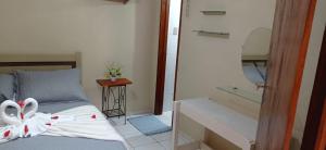 Un dormitorio con una cama con sábanas blancas y un espejo. en Casa na Serra, en Mulungu