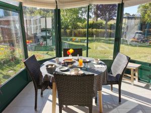 a dining room with a table and chairs on a patio at Plage du Pont - Chambres d'Hôtes in Saint Malo