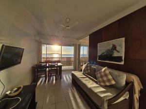 een woonkamer met een bank en een tafel bij Apart Edificio Vanguardia frente al mar in Punta del Este