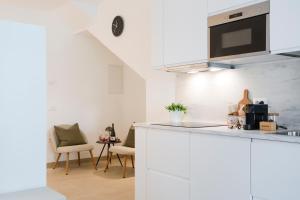 a kitchen with white cabinets and a table and chairs at Suite con spa privata disponibile su richiesta in Maso
