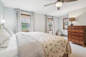 a bedroom with a bed and a dresser and windows at Fern and Fox Chalet in North Sherburne