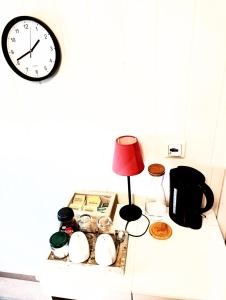 een plank met een klok, een lamp en andere spullen bij Dal Homestay Haven 4U in Dal