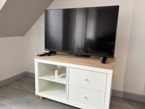 a flat screen tv on a white entertainment center at Cléanounette du Morvan in Saulieu