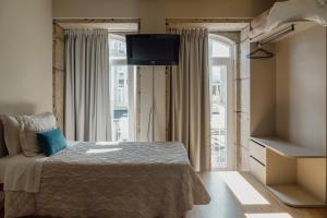 a bedroom with a bed and a large window at Residencial Portas do Sol in Valença
