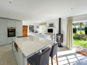 a kitchen with a large island with chairs and a stove at The Cottage - Uk50673 in Tangmere +20 photos