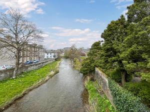 a river with trees on the side of it at Acreknowe Cottage in Hawick
