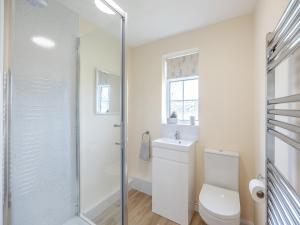 a white bathroom with a toilet and a shower at Oaks - Uk47372 in Burgh le Marsh +5 photos
