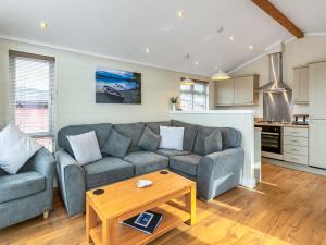 a living room with a couch and a table at 4 Lakeside Lodge in Troutbeck Bridge