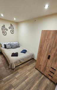 a bedroom with a bed and a large wooden door at Czarny Koń i Biały Koń Black Horse & White Horse Apartamenty in Kamienna Góra
