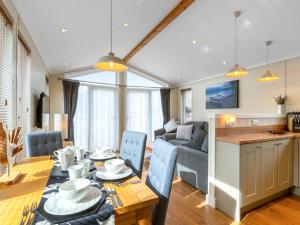 a kitchen and living room with a table and chairs at 4 Lakeside Lodge in Troutbeck Bridge