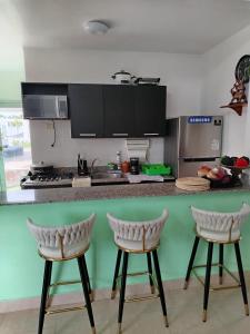 une cuisine avec deux tabourets de bar devant un comptoir dans l'établissement Recidencial Ibiza Beach Residences, à Calobrito