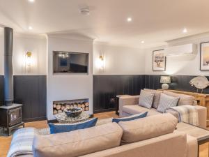 a living room with a couch and a fire place at Eachaig Cottage - Uk7812 in Coirantee