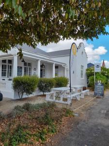 a white building with benches in front of it at Oz on M8re in Stanford