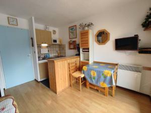 a kitchen with a table and a small kitchen with a table and chairs at Studio 25m² au Sauze, balcon Sud-Ouest, proche pistes - FR-1-804-15 in Enchastrayes