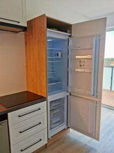 a kitchen with an empty refrigerator in a room at Perła Mórz 74 in Sianozety