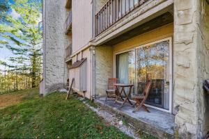 a patio with two chairs and a table next to a window at Whiffletree H1 in Killington Village
