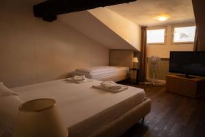 a bedroom with two beds and a flat screen tv at Residence Fink Central Apartments in Bolzano