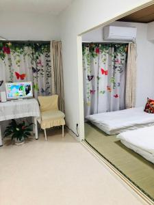 a room with two beds and a desk and a chair at Ikebukuro-hostel池袋中川301&501-TS0038 in Tokyo