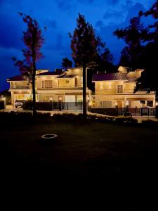 a large white house with trees in front of it at Queen's Villa Yercaud in Yercaud