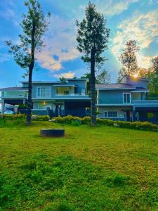 a house with trees in front of a yard at Queen's Villa Yercaud in Yercaud +3 photos