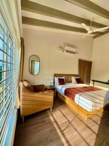 a bedroom with two beds and a chair and a window at Queen's Villa Yercaud in Yercaud