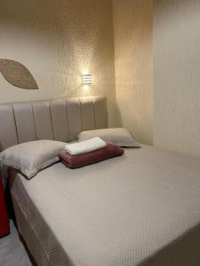 a bed with two pillows on it in a room at Suite Tarituba 3 in Angra dos Reis +11 photos