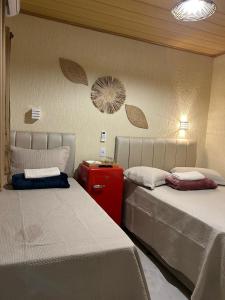 two beds sitting next to each other in a room at Suite Tarituba 3 in Angra dos Reis