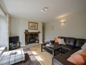 un salon avec un canapé et une cheminée dans l'établissement Holliers Cottage, à Ledwell