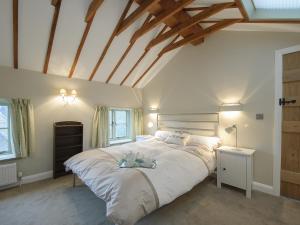 une chambre avec un grand lit avec un plafond en bois dans l'établissement Holliers Cottage, à Ledwell