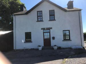 a white house with black windows and a door at Teachershouse in Figlash
