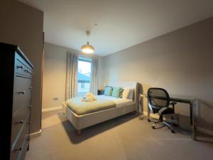 a bedroom with a bed and a desk and a chair at Bath St Suite in Glasgow
