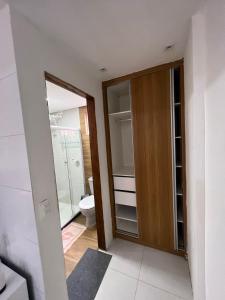 y baño con armario y aseo. en Flat Litoral, en Tamandaré