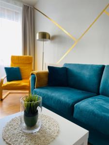 a living room with a blue couch and a table at Alpesi Apartman Downtown in Sopron