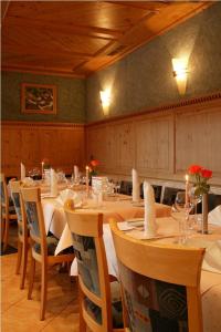 a dining room with tables and chairs with candles and flowers at Landgasthof Löwen in Neubulach