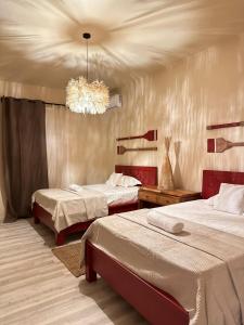a bedroom with two beds and a chandelier at Les Hauteurs de Brûlée in Rodrigues Island +27 photos
