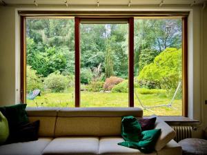 a living room with a couch and a large window at Unique retro bungalow on the Veluwe in Wageningen +50 photos