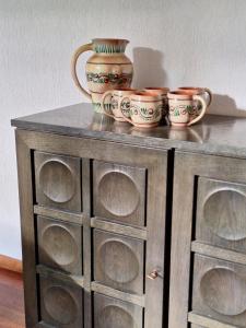 a wooden cabinet with four bowls on top of it at Unique retro bungalow on the Veluwe in Wageningen