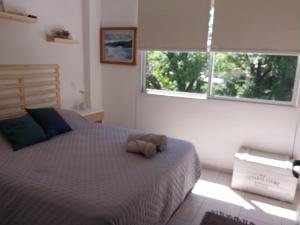 a bedroom with a bed with a stuffed animal on it at Pichincha departamento in Rosario