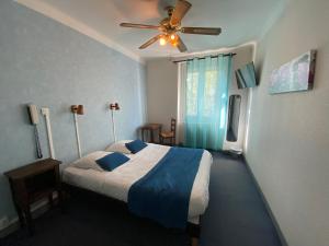 una camera da letto con un letto e un ventilatore a soffitto di Au Royal Hotel a Carcassonne
